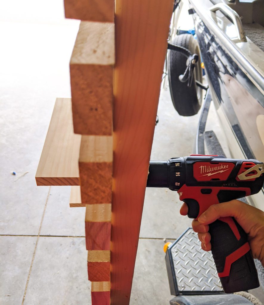 Attaching the shelves to the slat wall using screws and a drill