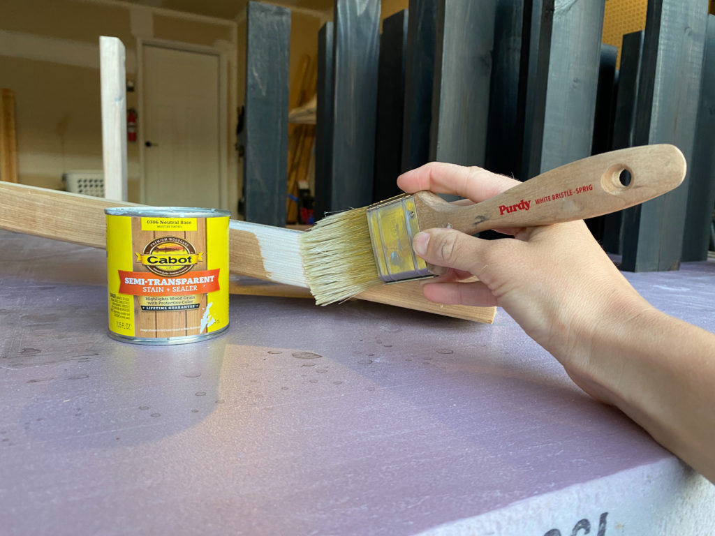 Applying white stain to boards for outdoor bench