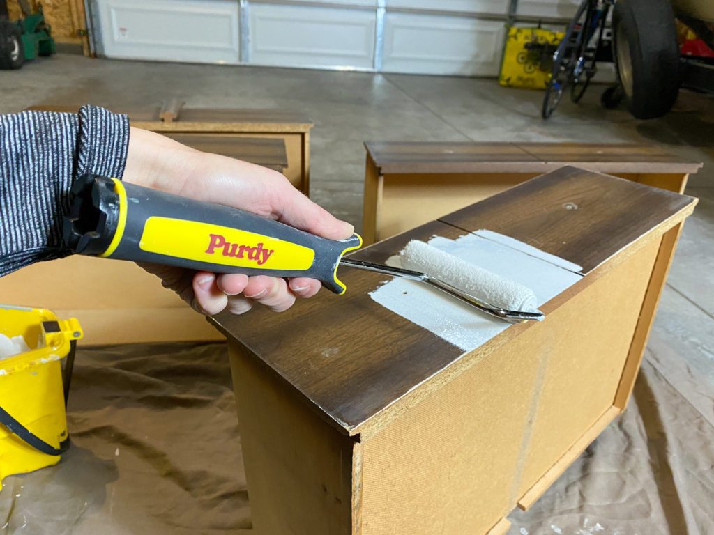 Applying primer to dresser before painting