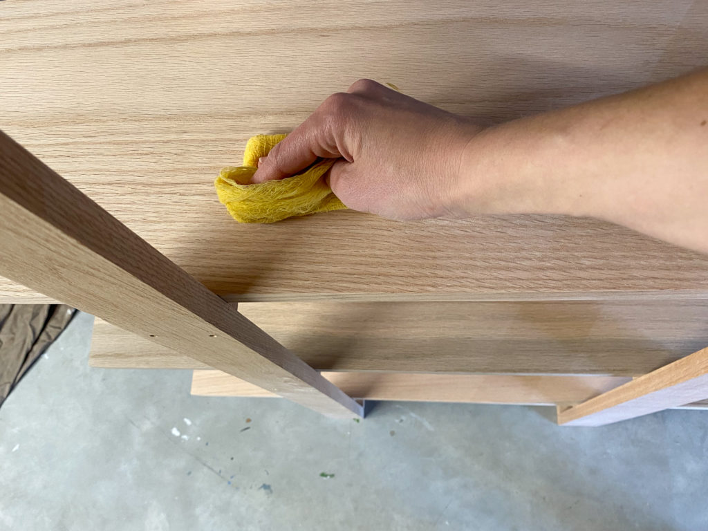 Using a tack cloth to remove sanding dust