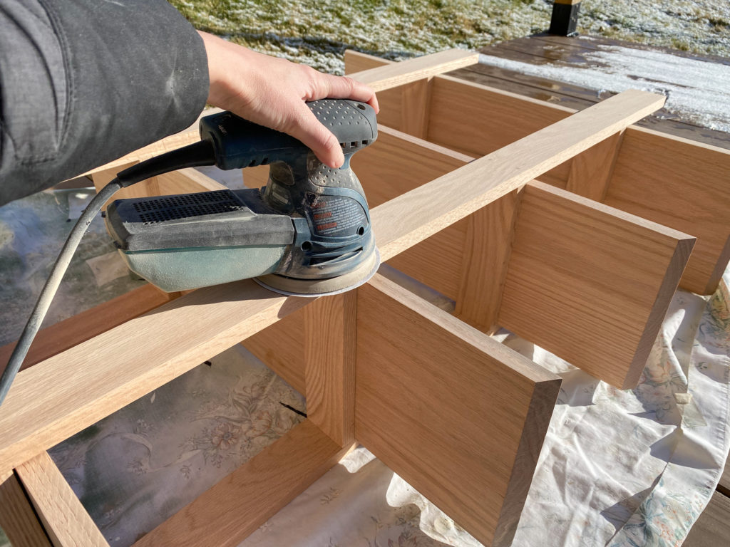 Sanding down the wood dowels that filled the screw holes